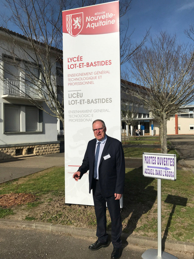 proviseur devant le panneau d'information du lycée 