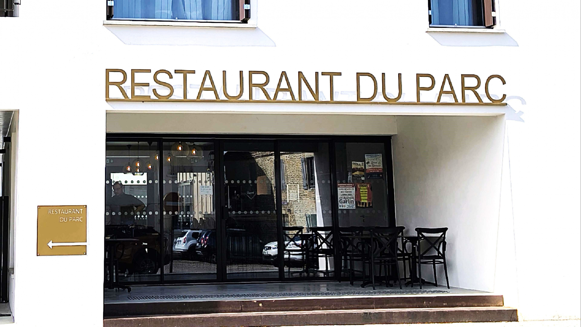 devanture du restaurant avec l'enseigne et quelques tables