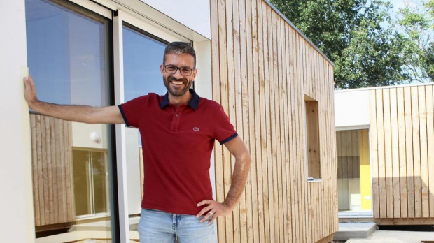 mairie de la commune posant devant l'un des containers