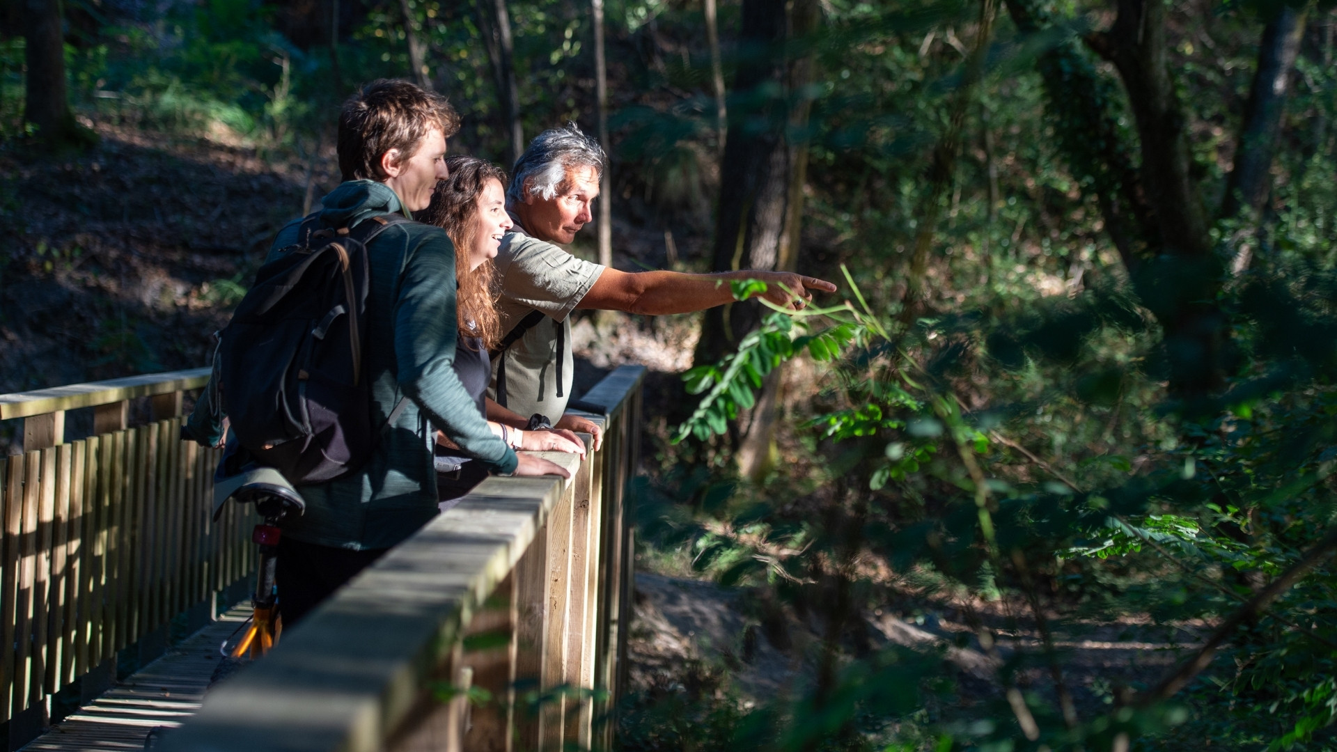 3 personnes sur un pont en bois en pleine nature