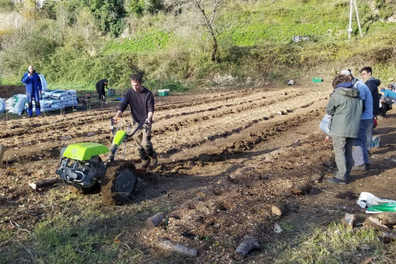 des personnes travaillant la terre à l'aide de machine