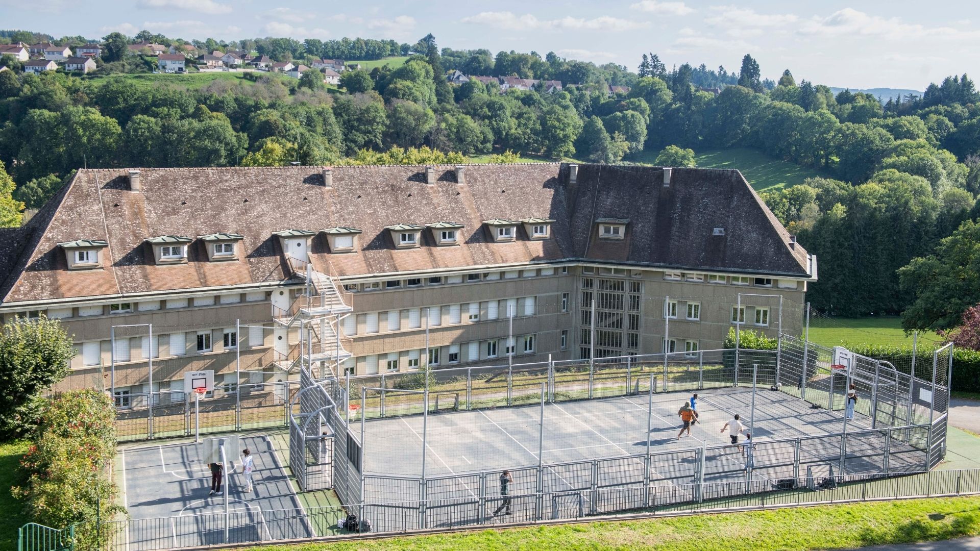 vue aérienne du bâtiment avec son terrain de basket extérieur