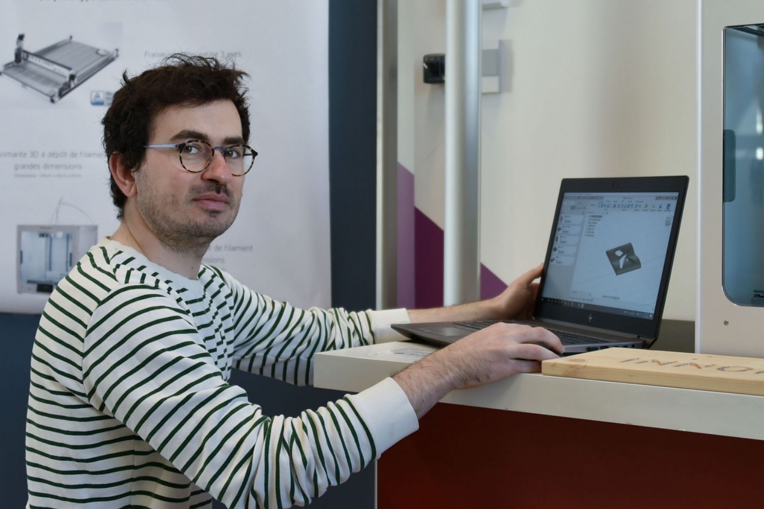 un homme sur un comptoir un ordinateur portable en main
