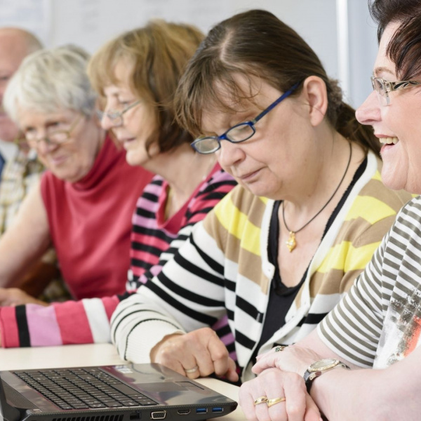 des personnes âgés plutôt actifs autour d'un ordinateur